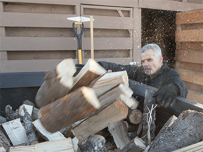 Jimmie Hutson loads firewood that he will use to help heat his home from a woodshed at the Willow (Alaska) Community Food Pantry. Hutson is both a regular volunteer at the pantry and occasionally receives aid from the program. Photo by Mike DuBose, UM News.