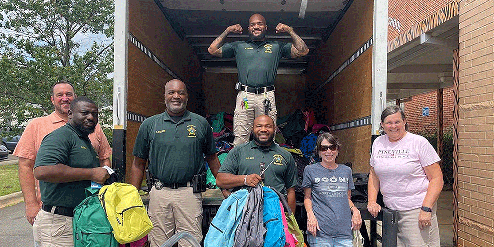 Back-to-School Backpack Event. Jane Shutt (far right) at a Back-to-School Backpack Event in 2022. Pineville Neighbors Place: Sharing Dignity, Hope And God’s Love.