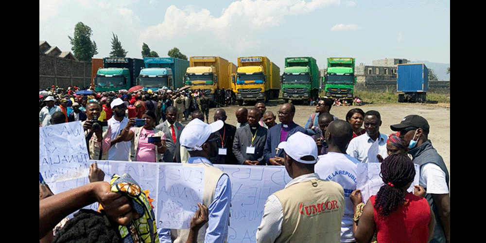 Kalehe flood survivors talk to Bishop Gabriel Yemba Unda of the East Congo Episcopal Area during a church distribution operation in Goma. In May, two rivers overflowed following torrential rains, killing more than 400 people in the area. The survivors asked the bishop to continue advocating on their behalf. Photo by Jolie Shabani, UM News.