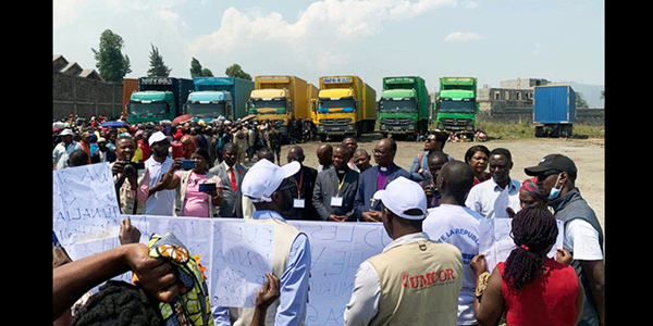 Kalehe flood survivors talk to Bishop Gabriel Yemba Unda of the East Congo Episcopal Area during a church distribution operation in Goma. In May, two rivers overflowed following torrential rains, killing more than 400 people in the area. The survivors asked the bishop to continue advocating on their behalf. Photo by Jolie Shabani, UM News.