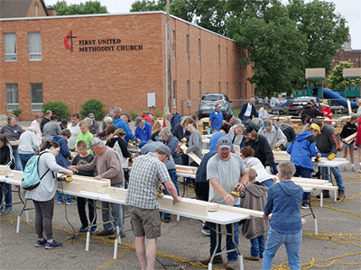 The sanding stations had the most workers busy. The wind blew sawdust in their eyes, but every board was finished. Courtesy photo.