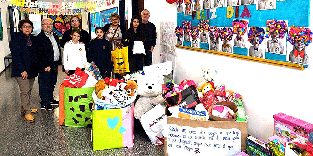 Missionary Luis de Souza Cardoso (second from left) and a group of students and teachers from Crandon Salto school displaying toys collected for a giving project for children in a nearby neighborhood. (Photo: Courtesy of Crandon Salto school)