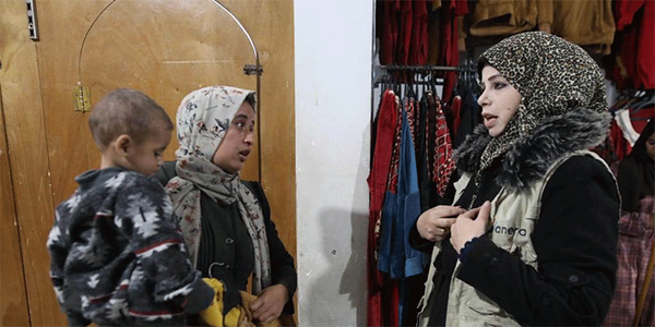 ANERA staff member assists a woman looking for winter clothes and a coat for her son. (Photo: Courtesy of ANERA) ANERA staff member assists a woman looking for winter clothes and a coat for her son. (Photo: Courtesy of ANERA)