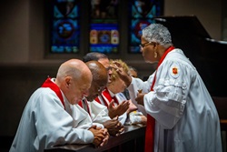 Bishop LaTrelle Easterling, who leads the Baltimore-Washington and Peninsula-Delaware conferences, anoints the forehead of Bishop Héctor A. Burgos-Núñez during the Northeastern Jurisdictional Conference held July 10-12 in Pittsburgh. To the left is Bishop John R. Schol and Bishop Marcus Matthews. Photo by James Lee, courtesy of the United Methodists of Eastern Pennsylvania Facebook page.