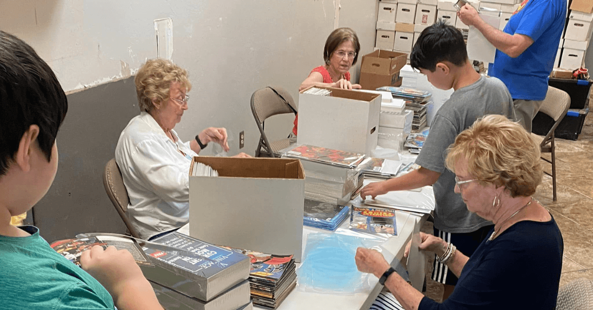Volunteers from Village UMC sort and price comics at Sanctuary Comics and Games