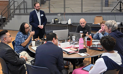 David Scott (standing), senior director of mission theology and strategic planning for the United Methodist Board of Global Ministries, listens to members of the Connectional Table discuss colonialism Oct. 24 during orientation training in Dallas. Photo by Jim Patterson, UM News.