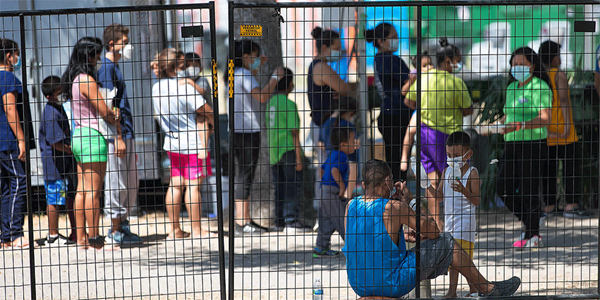 Migrants who have crossed into the U.S. from Mexico gather in Anzalduas Park in Mission, Texas. (Photo: Mike DuBose)