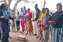 A Superintendente Distrital Victoria Chifeche distribui bíblias e hinários aos novos membros da Conferência Sul em Moçambique.