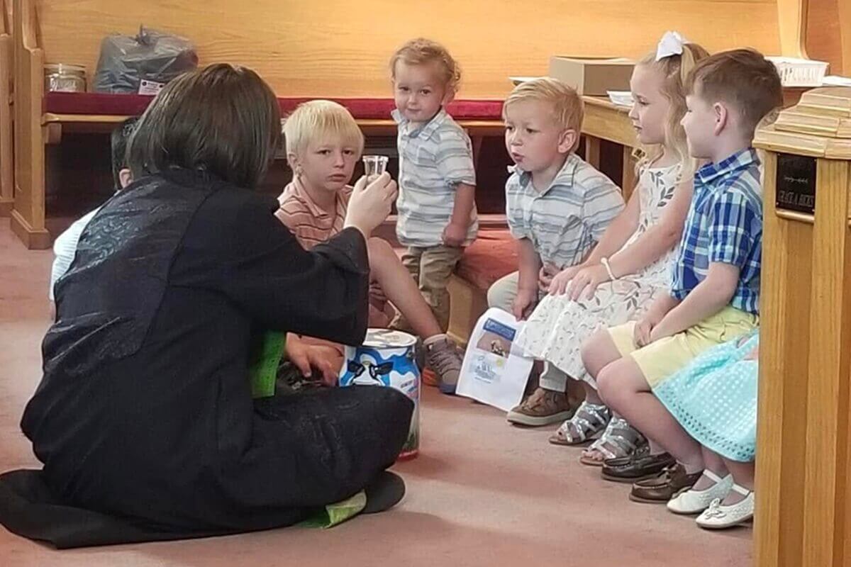 A Revda. Natalie Justice (à esquerda) continuou  cumprindo as suas duas congregações durante a sua segunda batalha contra o cancro. Ela diz: " O meu médico e os meus enfermeiros ficaram chocados com a minha ação, mas entregamos tudo a Deus". Nesta foto, ela lidera o culto usando uma peruca. Foto cortesia de Justice.