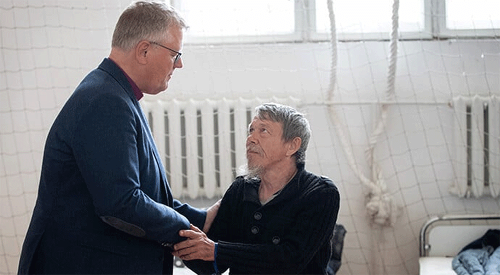 During a 2022 visit to Ukraine, United Methodist Bishop Christian Alsted visits with Alexandre, who is living in the gymnasium at the Onokivtsi Secondary School near Uzhhorod. Being present reassures victims of the war that the church has not forgotten them, Alsted said. File photo by Mike DuBose, UM News.