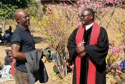 Danny Dube (left), a regular member of Morning Service in Nyanyadzi, Zimbabwe, talks with the Rev. Godfrey Gaga, Nyanyadzi Circuit pastor-in-charge, after a funeral. The 7 a.m. church service has transformed Dube, who had been known in the community for drinking and causing disturbances. “The circuit is meeting people where they are, offering a safe space for transformation and showing that the church is a place of healing rather than judgment,” says Bishop Gift K. Machinga. Photo by Kudzai Chingwe, UM News.