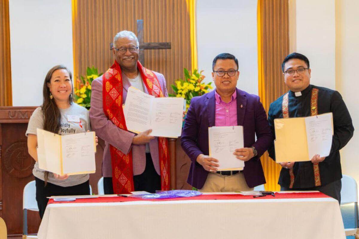 From left: The Rev. Allison Mark, Bishop Julius C. Trimble, Bishop Israel M. Painit, and Pastor Thaad Kolin Samson hold up the signed agreement.