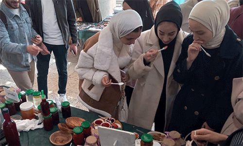 A group of young women taste some of the culinary creations of a participant in the Rural Women’s Development Society project. (Photo: Courtesy of RWDS)