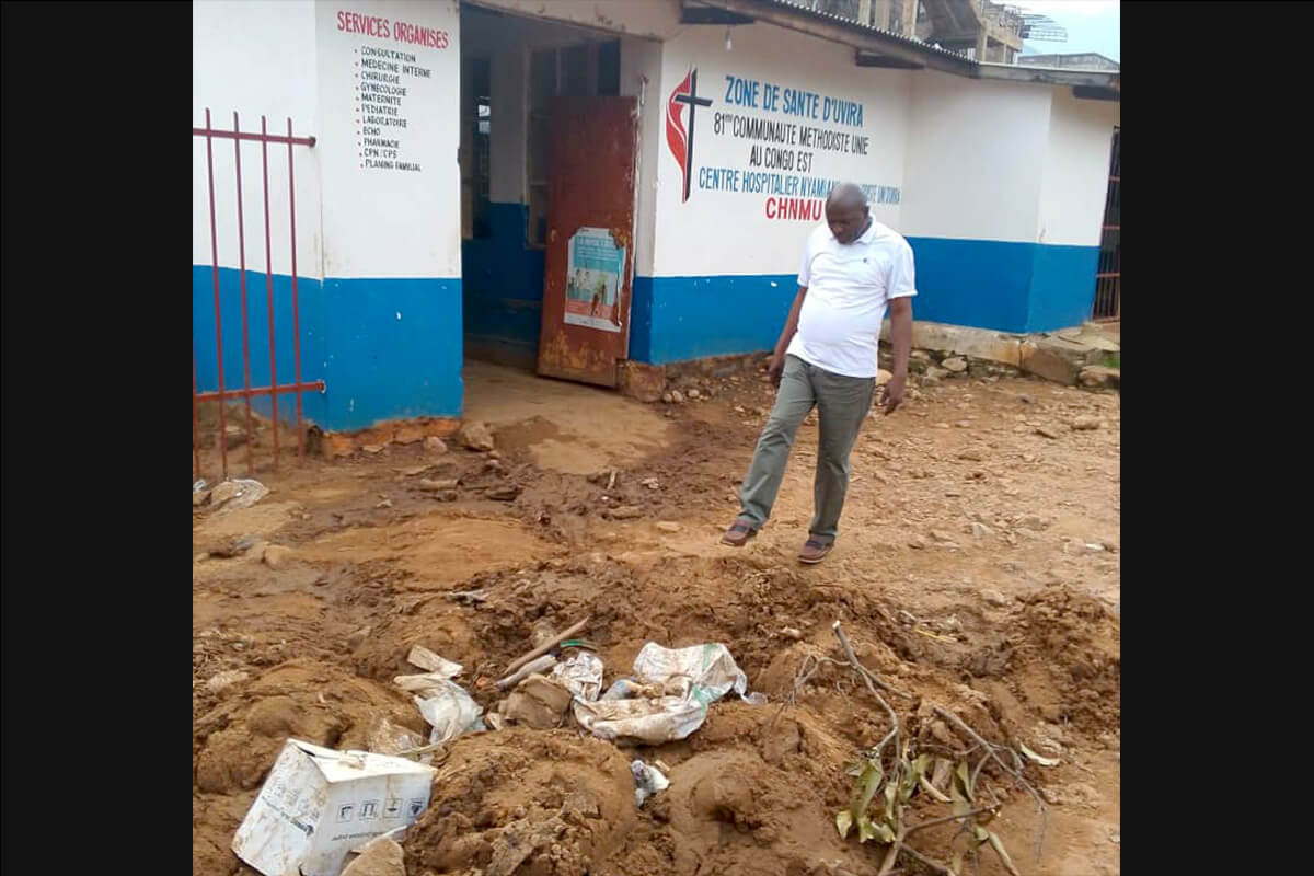 Le Dr Claude Watukalusu évalue l'étendue des dégâts dans la cour de l'hôpital méthodiste Nyamianda United, recouverte de boue et de débris. L'établissement est confronté à une grave urgence sanitaire après que des pluies torrentielles ont inondé ses services et détruit des équipements essentiels le 5 janvier. Photo gracieusement fournie par le département de la santé de l'est du Congo.