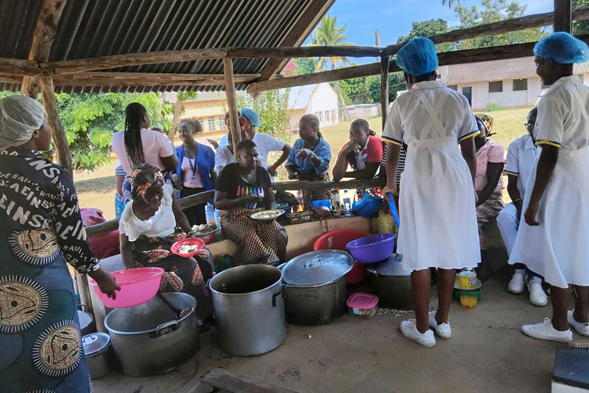 Des femmes du District de Morrumbene, au Mozambique, apprennent à cuisiner et à se nourrir sainement lors d'une démonstration organisée par la clinique mobile Méthodiste Unie lors d'une récente visite dans la région. La clinique se rend dans des zones reculées pour offrir des services de santé essentiels tels que des examens de base, des soins maternels et infantiles, des vaccinations et des soins dentaires. Photo prise par la Révérende Maria Matsinhe.