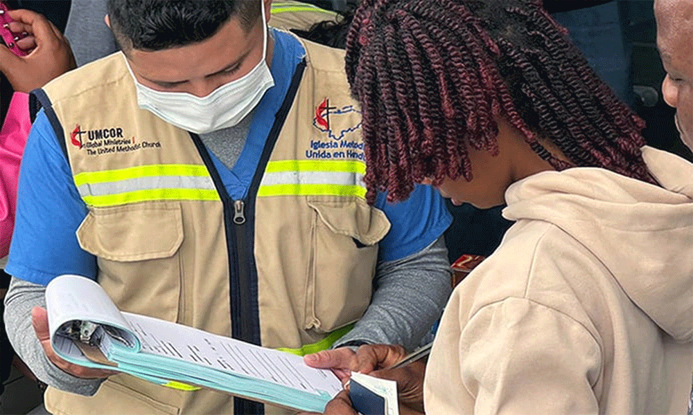 Yilmer Duarte (left), with the United Methodist clinic, helps a migrant seeking health services at the Irregular Migrant Assistance Center in Danlí, Honduras. Photo by the Rev. Gustavo Vásquez, UM News.