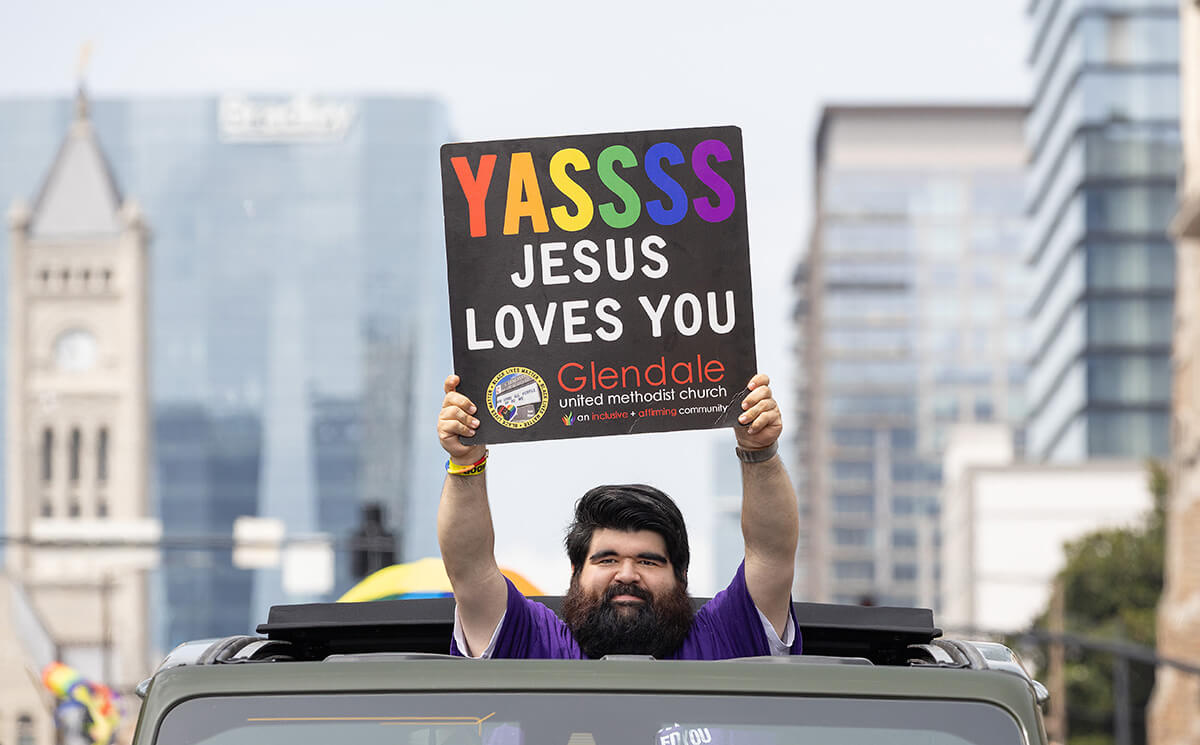 Mark Lynes shares a message of love while holding a sign through the open sunroof of a vehicle in the Nashville (Tenn.) Pride Parade. Lynes is a member of Glendale United Methodist Church in Nashville, which has seen membership growth due to its inclusivity efforts.
