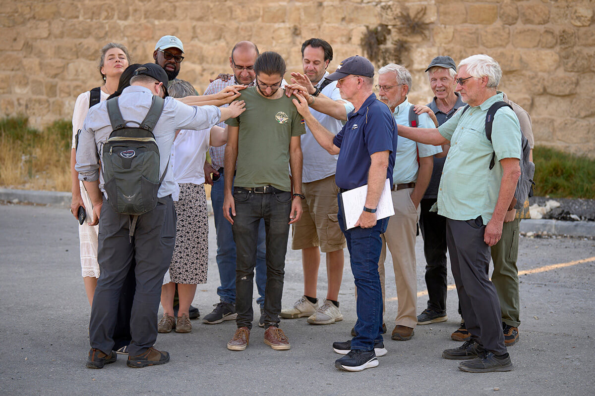 En esta fotografía de archivo de 2024, una delegación visitante de activistas eclesiásticos de Estados Unidos ora por Setrag Balian en el centro, un líder de la lucha encabezada por jóvenes para salvar el Barrio Armenio de la Ciudad Vieja de Jerusalén. La delegación viajó a Oriente Medio para acompañar a cristianos/as y otros/as palestinos/as amenazados/as, y exigir un alto el fuego en Gaza. Una delegación interreligiosa estadounidense similar que viajaba a Israel y Palestina para reunirse con cristianos/as en Tierra Santa, fue rechazada en la frontera israelí el 13 de agosto. El grupo incluía a cuatro metodistas unidos. Fotografía de archivo de Paul Jeffrey, Vida en Fotos de la Tierra.