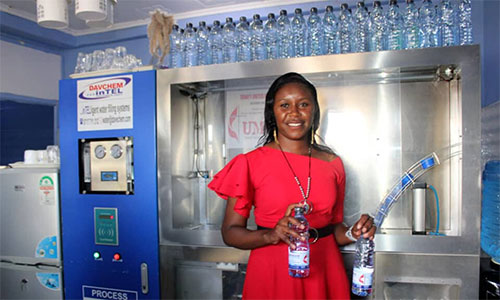 Project Manager Tabitha Waithira, of Trinity UMC in Naivasha, Kenya, demonstrates the water filling station and filtration system funded by an UMCOR grant. Photo: Kudzai Chingwe .