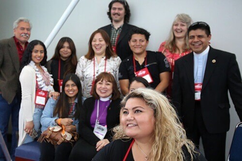 Yenifer Posadas uses her selfie stick to take a photo of Bishop Minerva Carcaño and other Hispanic/Latino young adults in a lobby of the Oregon Convention Center during the 2016 United Methodist General Conference. Photo by Kathleen Barry, UMNS