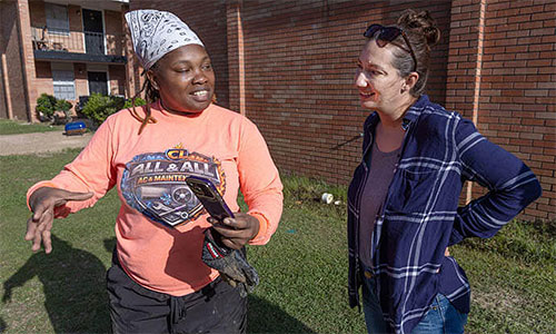 Crystal Latham (left) shows Ruth Mazara pictures of some construction jobs she’s working on. Latham, a graduate of the Women in Construction program in Biloxi, Miss., owns her own plumbing and remodeling business. Mazara, director of the training program, dropped by to visit Latham at the apartment complex where she was working in Gulfport.