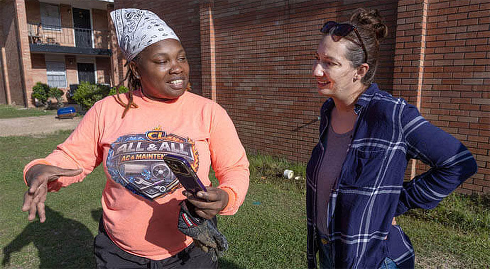 Crystal Latham (left) shows Ruth Mazara pictures of some construction jobs she’s working on. Latham, a graduate of the Women in Construction program in Biloxi, Miss., owns her own plumbing and remodeling business. Mazara, director of the training program, dropped by to visit Latham at the apartment complex where she was working in Gulfport.