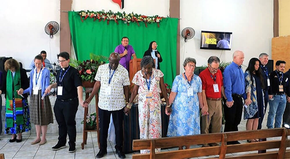 Bishop Juan de Dios Peña leads a prayer of thanksgiving for the presence of delegates attending the World Methodist Council meeting at the Evangelical Methodist Church of Ahuachapán in San Salvador. “The presence and participation of Methodist leaders from different parts of the world in local Salvadoran churches has been a powerful encouragement for local pastors and leaders,” Peña said. Photo courtesy of the Evangelical Methodist Church of El Salvador. Greater visibility for the church.